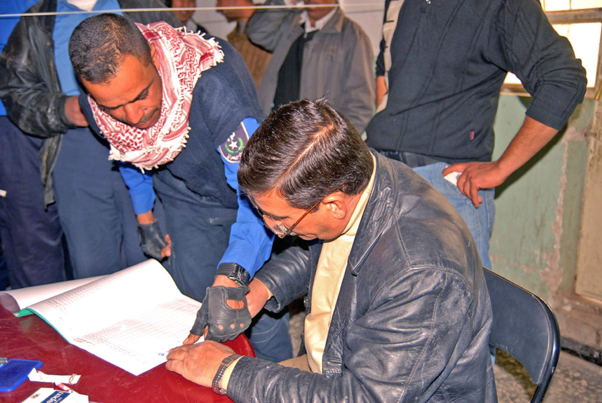An officer from the Hy al Amil Iraqi Police Station places his fingerprint on a pay form after receiving his monthly pay and injury compensation wage Jan. 30 at the Joint Security Station Black Lion in Baghdad, Iraq. Nearly two hundred Iraqi police officers receive their monthly pay with the help of U.S. expeditionary security forces members. (U.S. Army photo/Sgt. Daniel Blottenberger) 