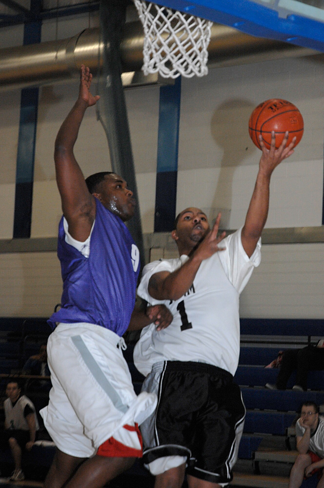Kevin Johnson, 48th Communications Squadron, goes up for a lay-up as Jovon Stafford, 48th Civil Engineer Squadron, goes in for the block during an intramural basketball game Jan. 30 at RAF Lakenheath, England. The 48th CS lost to the 48th CES 51-34. (U.S. Air Force photo by Senior Airman Brian Ellis)