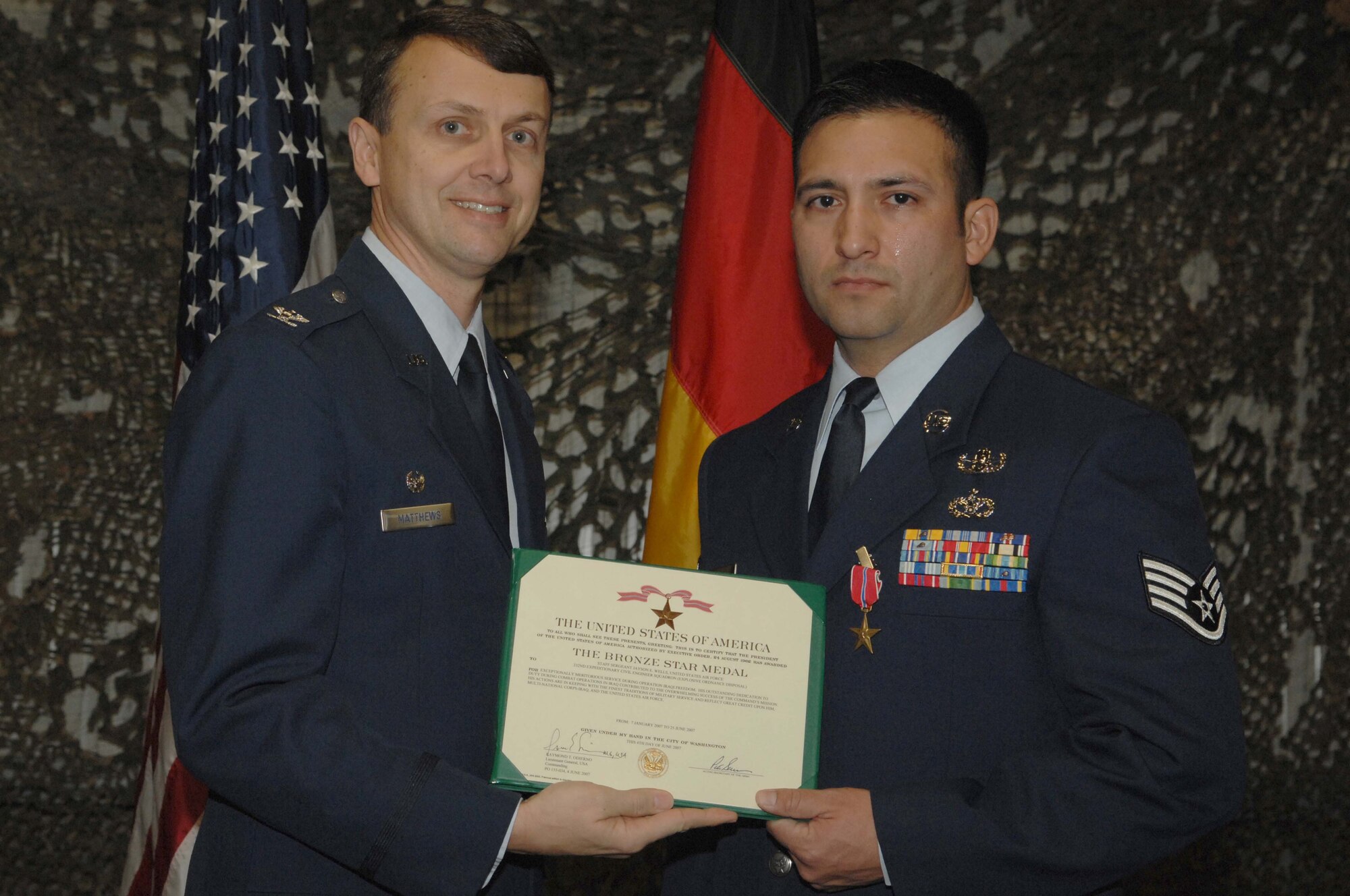 (left) Col. Earl Matthew, 435th Air Base Wing and KMC commander, presents the Bronze Star Medal and Air Force Combat Action Medal to Staff Sgt. Jayson Wells, 435th Civil Engineer Squadron, Explosive Ordnance Disposal flight, Jan. 24. (U.S. Air Force photo/Airman 1st Class Amber Bressler)