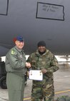 MINOT AIR FORCE BASE, N.D. -- Col. Joel Westa, 5th Bomb Wing commander, presents Staff Sgt. Kess Holmes with a certificate after Sergeant Holmes was awarded the position of dedicated crew chief to the wing flagship. (U.S. Air Force photo by Senior Airman Cassandra Jones)