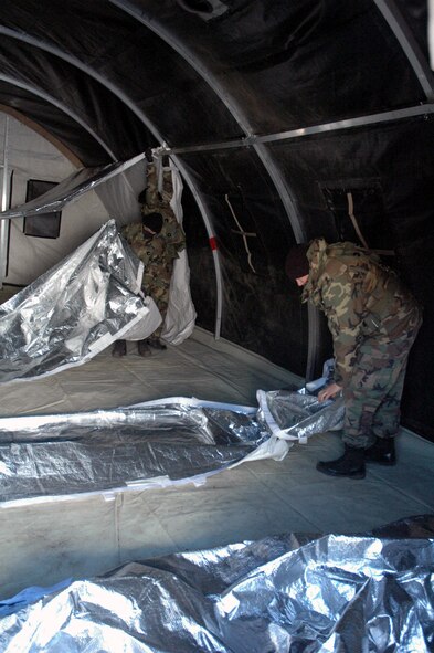 Airmen assigned to the fictional 421st Air Expeditionary Group work together to assemble an Alaskan shelter during camp build-up for Air Force Exercise Eagle Flag 08-2 Jan. 21, 2008, at Naval Air Engineering Station Lakehurst, N.J.  The exercise is operated by the U.S. Air Force Expeditionary Center's Expeditionary Operations School and 421st Combat Training Squadron from Fort Dix, N.J.  (U.S. Air Force Photo/Tech. Sgt. Scott T. Sturkol)