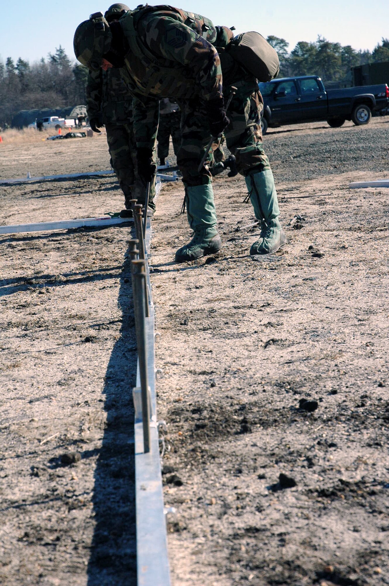 Airmen assigned to the fictional 421st Air Expeditionary Group place in stakes for an Alaskan shelter during camp build-up for Air Force Exercise Eagle Flag 08-2 Jan. 21, 2008, at Naval Air Engineering Station Lakehurst, N.J.  The exercise is operated by the U.S. Air Force Expeditionary Center's Expeditionary Operations School and 421st Combat Training Squadron from Fort Dix, N.J.  (U.S. Air Force Photo/Tech. Sgt. Scott T. Sturkol)