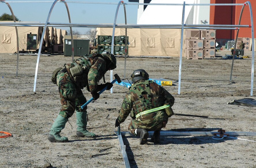 Airmen assigned to the fictional 421st Air Expeditionary Group pound in stakes for an Alaskan shelter during camp build-up for Air Force Exercise Eagle Flag 08-2 Jan. 21, 2008, at Naval Air Engineering Station Lakehurst, N.J.  The exercise is operated by the U.S. Air Force Expeditionary Center's Expeditionary Operations School and 421st Combat Training Squadron from Fort Dix, N.J.  (U.S. Air Force Photo/Tech. Sgt. Scott T. Sturkol)
