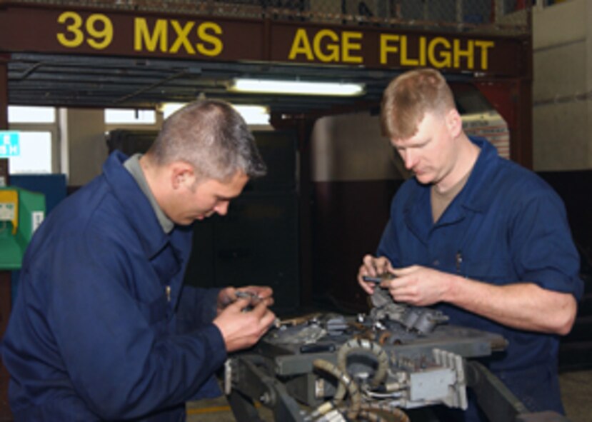 Staff Sgts. Steven Ransted and Jason Allen, 39th Maintenance Squadron Aerospace Ground Equipment craftsmen, rebuild the tilt cylinders on the table of a weapons loader Jan. 29. 