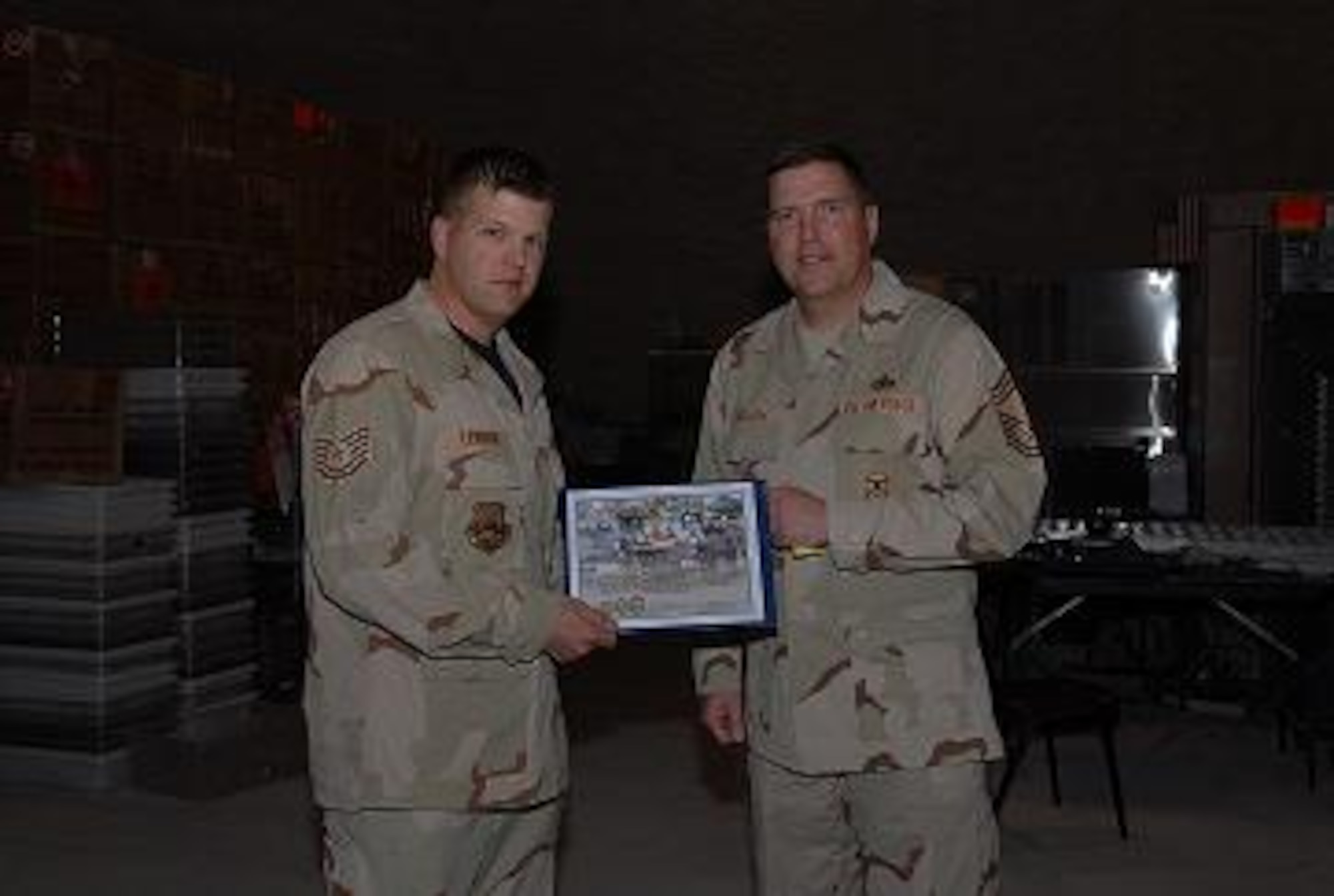 Chief Master Sgt. Eric Welsh presents Tech. Sgt. Jason E. Lewison the December Hard Charger award, Non-commissioned Officer category. (Courtesy photo) 