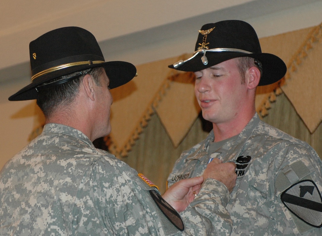 Army Chief Warrant Officer 3 Zachary Johnson (right), a pilot with 4th Battalion, 227th Aviation Regiment, 1st Cavalry Division, gets pinned with the Distinguished Flying Cross by Army Maj. Gen. Joseph F. Fil Jr., 1st Cavalry Division's commander, at the Fort Hood Catering and Conference Center on Jan. 28, 2008. Johnson, a Nampa, Idaho, native, was rewarded for his leadership and skills during a large battle in Najaf, Iraq, Jan. 28, 2007. Photo by Sgt. Nicole Kojetin, USA