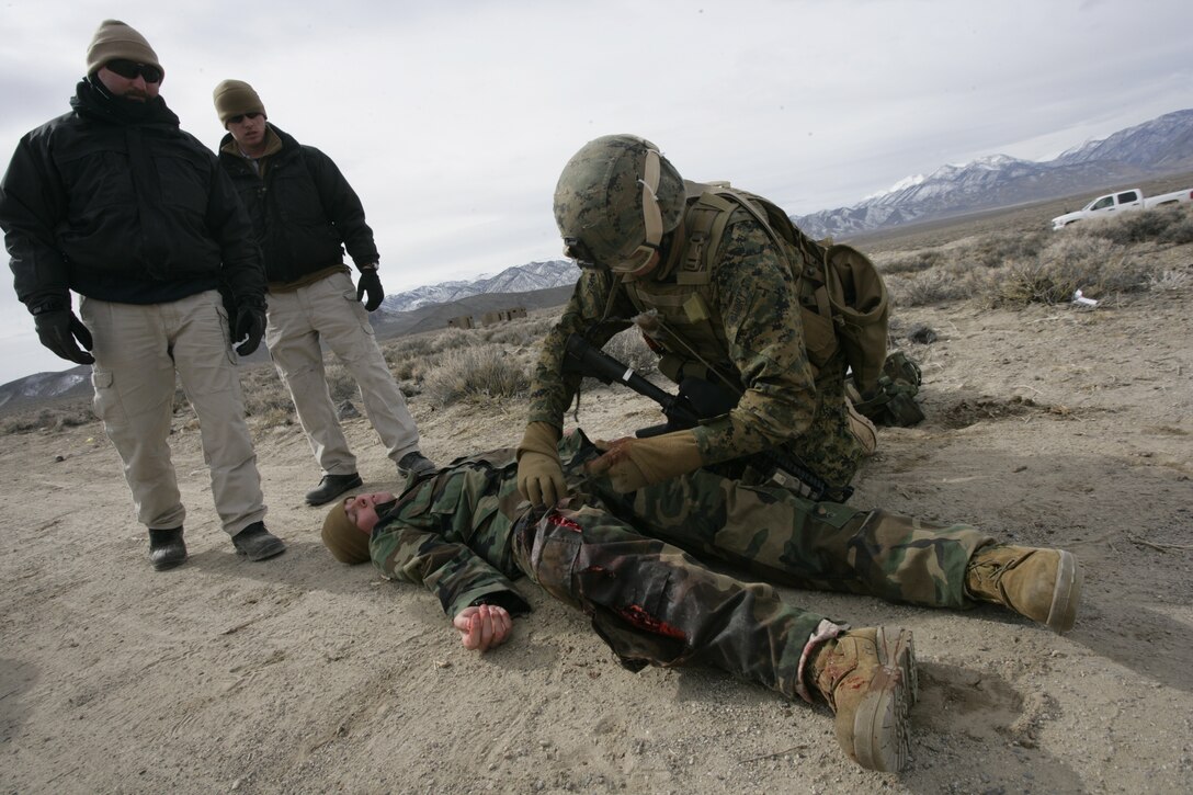Seaman Jimmy Guidry, a U.S. Navy corpsman with Embedded Trainer Team 5-3, applies a tourniquet to the leg of a mock-casualty as moutain warfare instructors look on during a casualty evacuation training exercise in Hawthorne, Nev., Feb. 2, 2008.  U.S. Marines and sailors with Embedded Trainer Teams, all serving with 3rd Marine Division, executed a training lane aboard U.S. Army training grounds surrounding Hawthorn Army Depot that involved mass casualty evacuation, immediate action to improvised explosive devices and ambush counterattacks.  The training lane is part of a pre-deployment package dubbed Mountain Viper.  ETT 5-3 are preparing for an upcoming deployment to Afghanistan where they?ll be tasked with mentoring, monitoring and advising Afghan army units to become a self-capable military force.  (U.S. Marine Corps photo by Cpl. Michael S. Cifuentes)