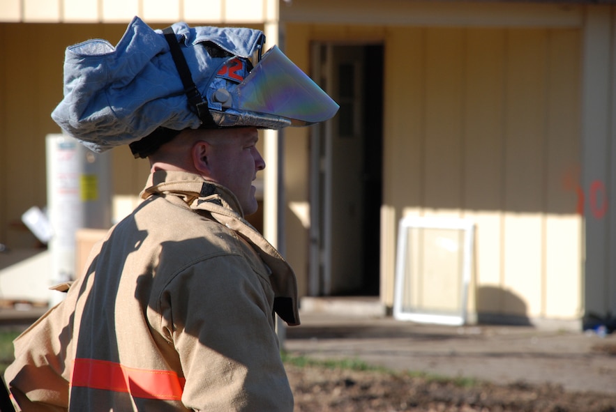 Even in cool outdoor temperatures, the heat generated inside a firefighter's suit and mask can be intense.  One 932nd Airlift Wing firefighter raises his mask to get cool air during a recent drill.  These "Citizen Airmen" constantly practice to stay ready and many work in Illinois and Missouri communities for civilian fire stations.  Photo/Capt. Stan Paregien