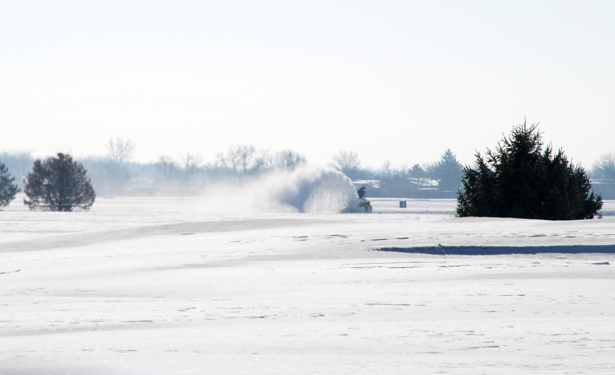A snow removal machine clears the first snowfall of 2008 near where the 932nd Airlift Wing operates its C-40C and C-9C planes.