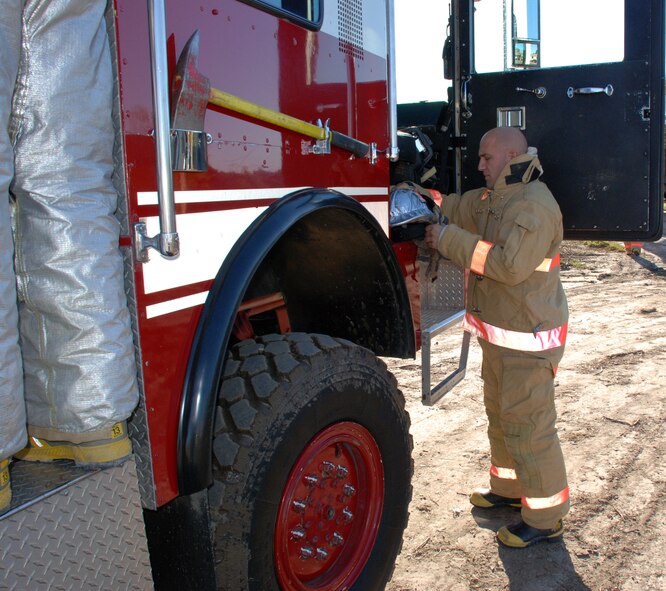 932nd Airlift Wing firefighters constantly practice to stay ready. Here, a firefighter gets his helmet and suit on as he prepares to enter simulated smoke; this is designed to teach firefighters to understand how their field of vision and awareness of surroundings is affected by thick smoke. 932nd Airlift Wing firefighters constantly practice to stay ready.  Interested in the Air Force Reserve Command firefighting program? Call 1-800-257-1212 for more information on openings and training required. Photo/Capt. Stan Paregien 