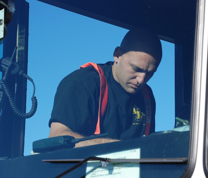 932nd Airlift Wing firefighters prepare to stay ready.  Here, a firefighter in the cab of the fire truck listens to the radio as other units respond to assist during a drill.  He gets his fire retardant suit on as he prepares to enter simulated smoke; this is designed to teach firefighters to understand how their field of vision and awareness of surroundings is affected by thick smoke. Heat can be a problem especially when wearing the heavy gear.  932nd Airlift Wing firefighters constantly practice to stay ready.  Interested in the Air Force Reserve Command firefighting program? Call 1-800-257-1212 for more information on openings and training required. Photo/Capt. Stan Paregien 