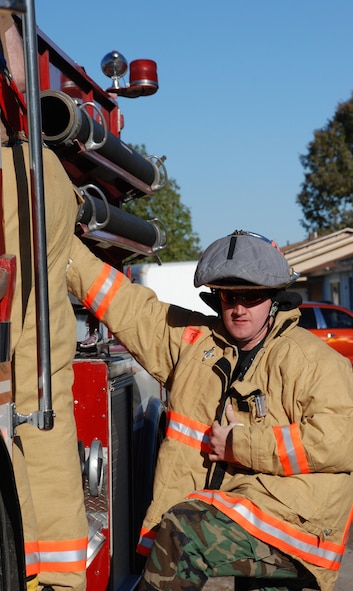 Air Force Reservists from the 932nd Airlift Wing constantly practice to stay ready. Here, a firefighter gets his fire retardant suit on and steps off the fire truck, as he prepares to enter simulated smoke during a recent drill; this is designed to teach firefighters to understand how their field of vision and awareness of surroundings is affected by thick smoke. Heat can be a problem especially when wearing the heavy gear.  932nd Airlift Wing firefighters are continously studying and training.  Interested in the Air Force Reserve Command firefighting program? Call 1-800-257-1212 for more information on openings and training required. Photo/Capt. Stan Paregien 