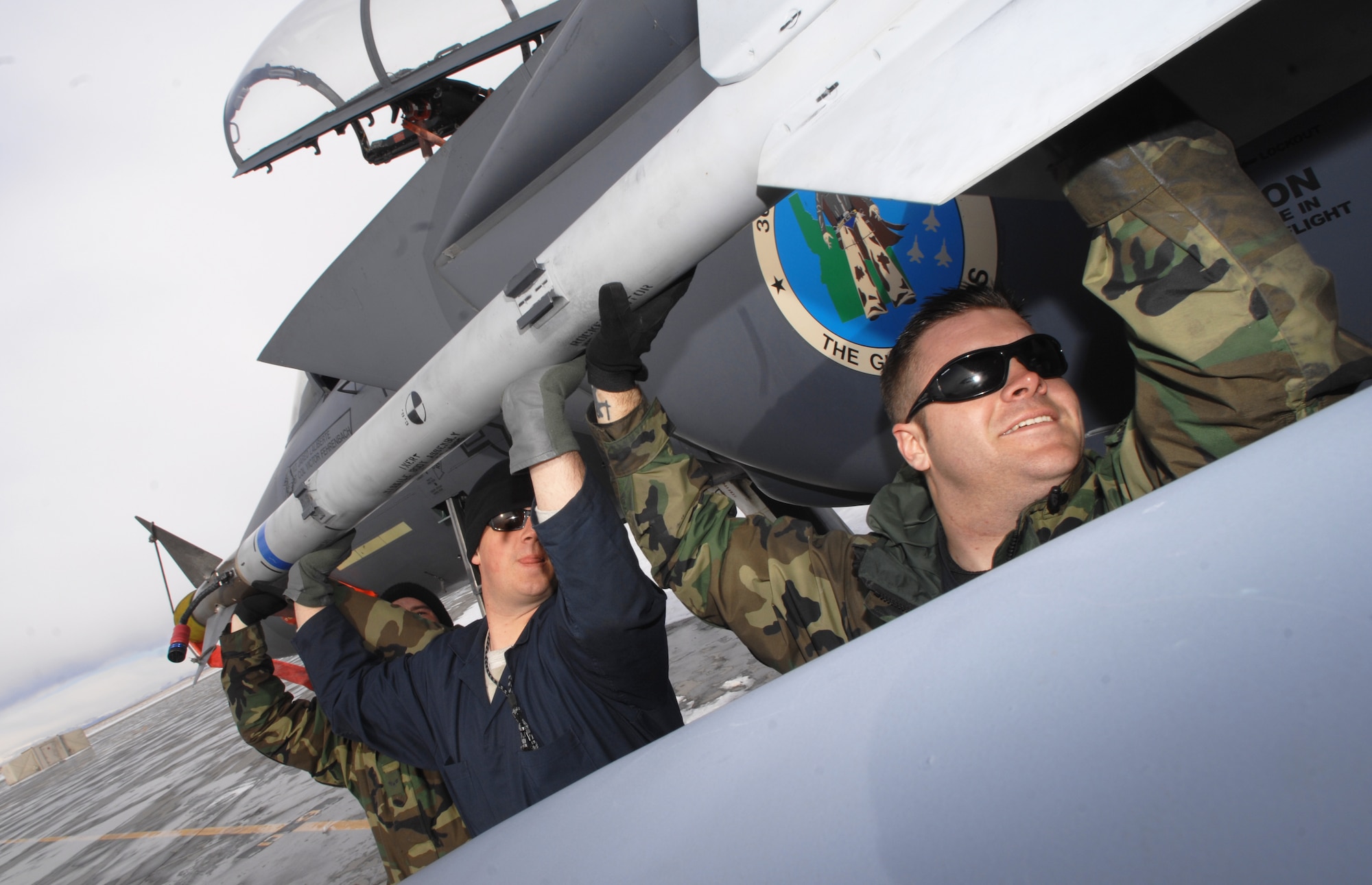 MOUNTAIN HOME AIR FORCE BASE, Idaho -- Staff Sgts. Charles Frazier and Dane Sherin and Airman 1st Class Craig Peterson, 366th Aircraft Maintenance Squadron load crew team, load an M-9 missile onto an F-15E Strike Eagle during the Phase I portion of Exercise Sharpshooter 08-03 here, Feb 1. Units across the base are participating in the exercise to prepare personnel and equipment for the upcoming March 2008 Operational Readiness Inspection. (U.S. Air Force photo/ Airman 1st Class Ryan Crane)