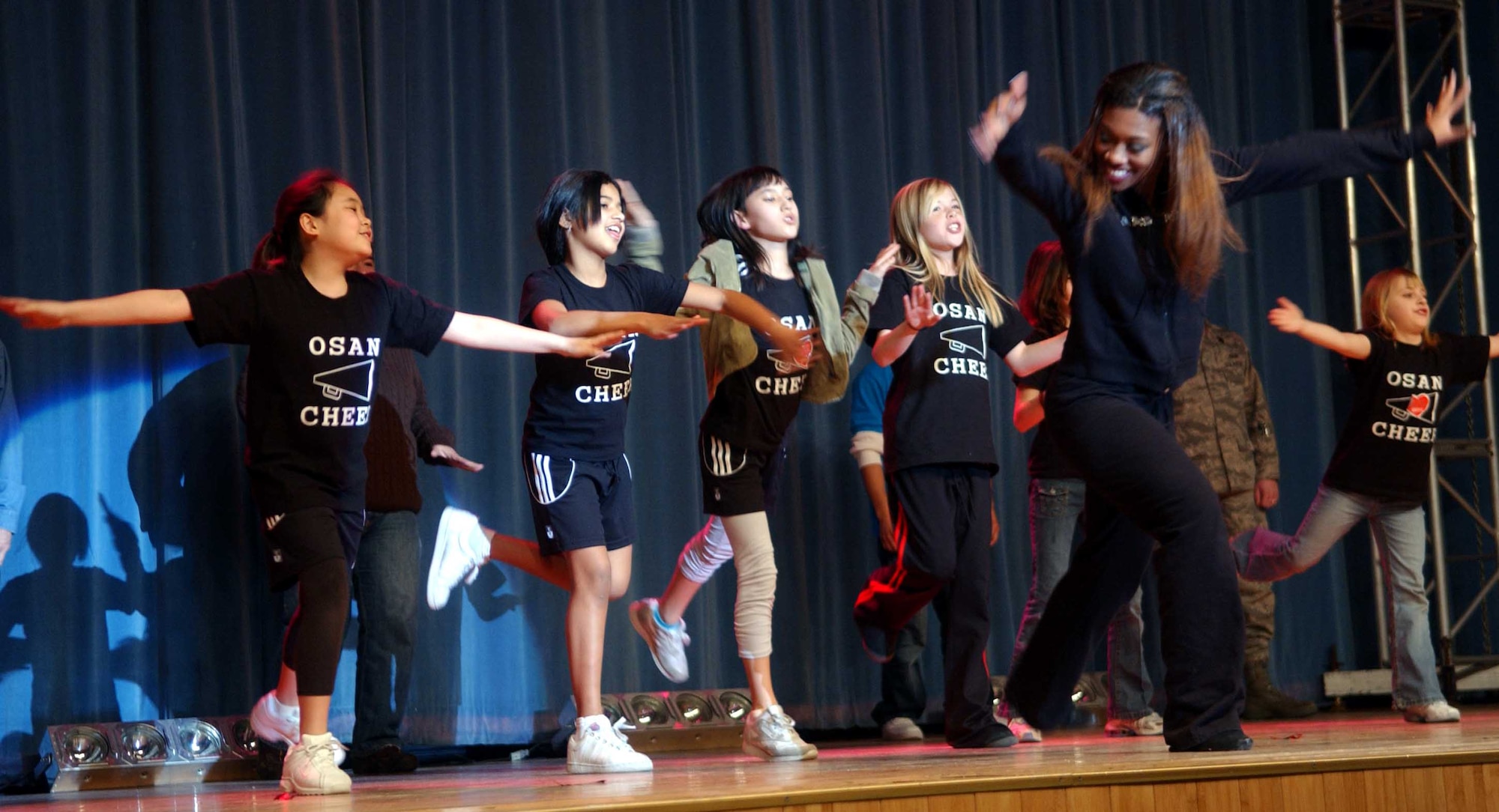 OSAN AIR BASE, Republic of Korea -- Members of the Osan's Youth Center do their best Superman impression during the Hip-Hop portion of the Arizona Cardinals Show Team performance Feb. 2. The show included an array of dances and audience participation games. Approximately 150 people attended the show. (U.S. Air Force photo/Staff Sgt. Candy Knight)
