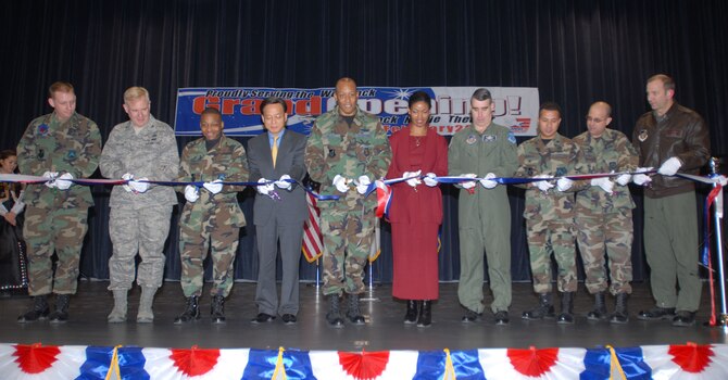 KUNSAN AIR BASE, South Korea -- Col. C.Q. "Wolf" Brown (center), 8th Fighter Wing commander and Brig. Gen. Harold Moulton (4th from right), 7th Air Force vice commander along with other key leadership involved in the new theater project cut the ribbon during the theater grand opening here Feb. 1.  The new theater has 200 more seats than the previous theater that was built in 1962.  The increase in capacity will enable the Wolf Pack to accept follow on forces more efficiently.  (U.S. Air Force photo/Staff Sgt. Darcie Ibidapo)