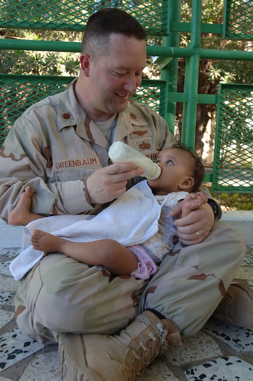 DJIBOUTI - Air Force Maj. Lanny Greenbaum feeds a baby during a visit to a Djibouti baby orphanage to help French nuns who run the facility for more than 60 babies and toddlers. Major Greenbaum, a Plain City, Ohio, native, is the Combined Joint Task Force-Horn of Africa information management officer. Servicemembers supporting the CJTF-HOA mission donate their time three times a week to help French nuns who run the facility feed the babies at dinner time. More than 60 babies and toddlers are cared for at the facility. (U.S. Air Force photo/Staff Sgt. Jennifer Redente)