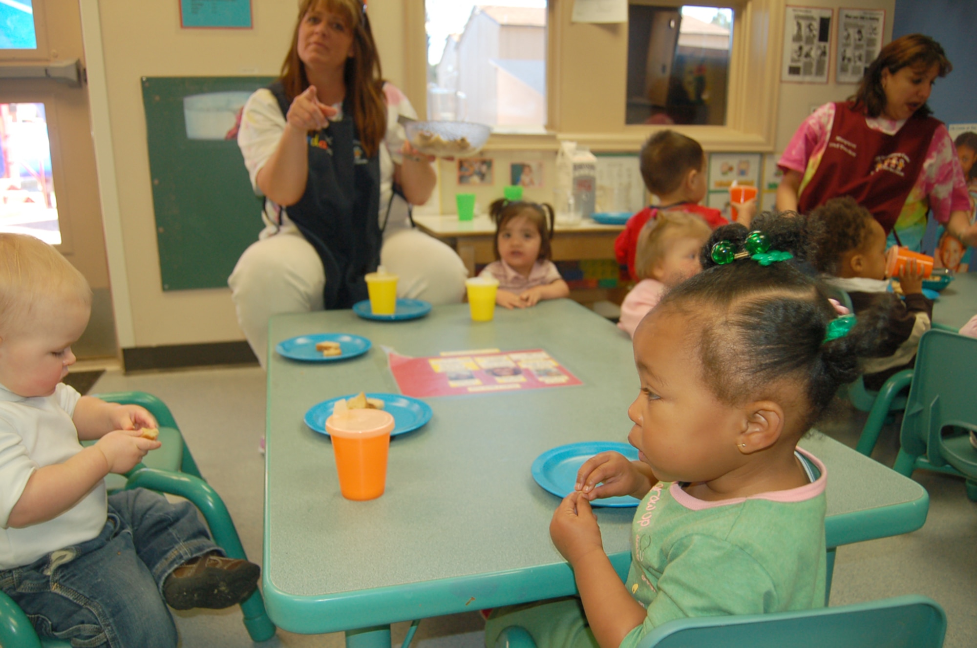 Children at the Peterson Child Development Center practice showing off their ‘more’ signs to each other. The center’s infants and toddlers are learning simple sign language as part of the Baby Signs program. (U.S. Air Force photo/Corey Dahl)