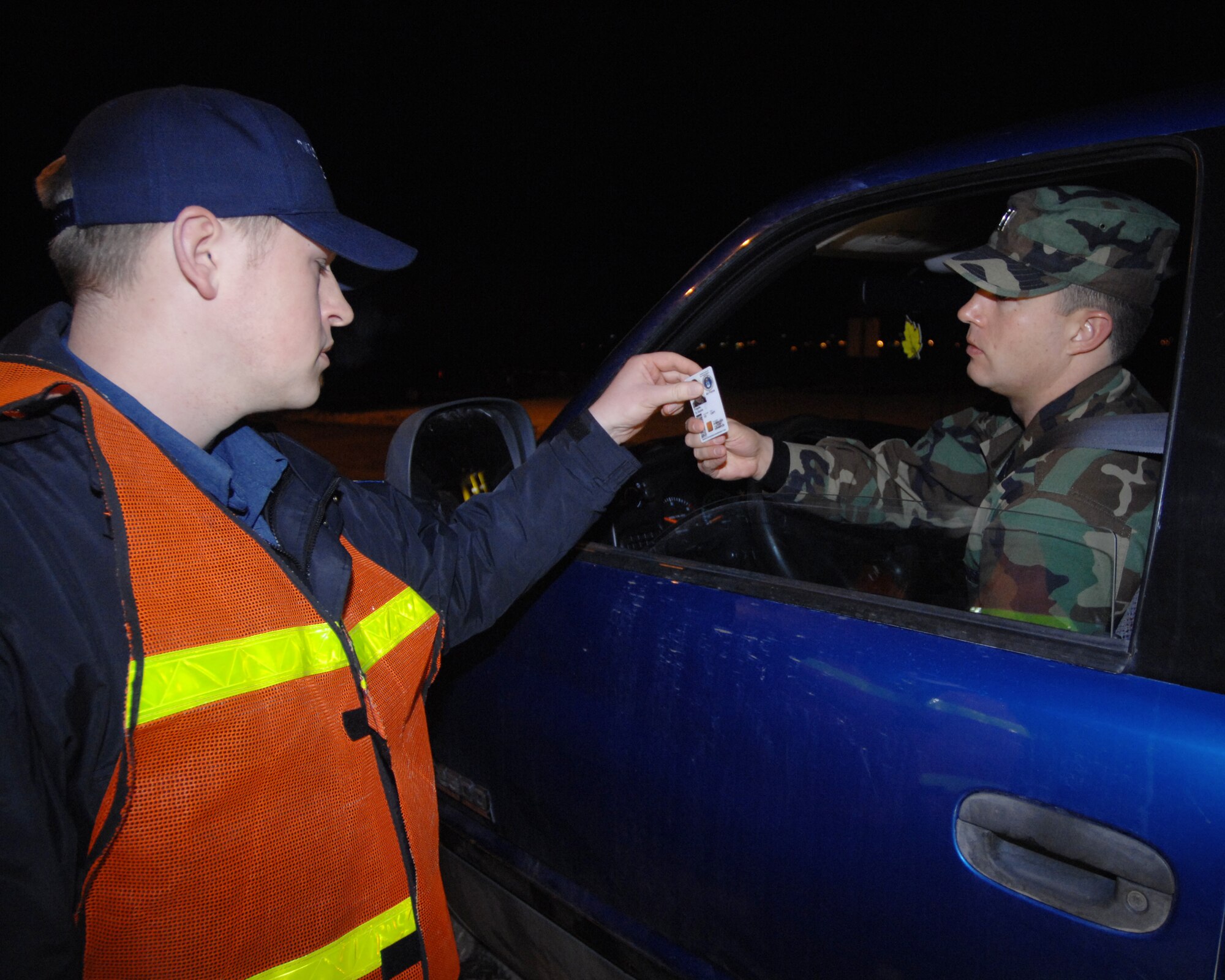 MOUNTAIN HOME AIR FORCE BASE, Idaho -- Daniel Bates, base security officer, inspects Capt. Ty Tripple’s, 366th Fighter Wing Staff executive officer, identification card while the base is in force protection level Bravo during Exercise Sharpshooter 08-03 here, Feb. 4. The base security officers are the first line of defense against unauthorized personnel gaining access to the base. The 366th Fighter Wing conducts exercises to prepare personnel and equipment for the upcoming March 2008 Operational Readiness Inspection. (U.S. Air Force photo by Airman 1st Class Ryan Crane) 