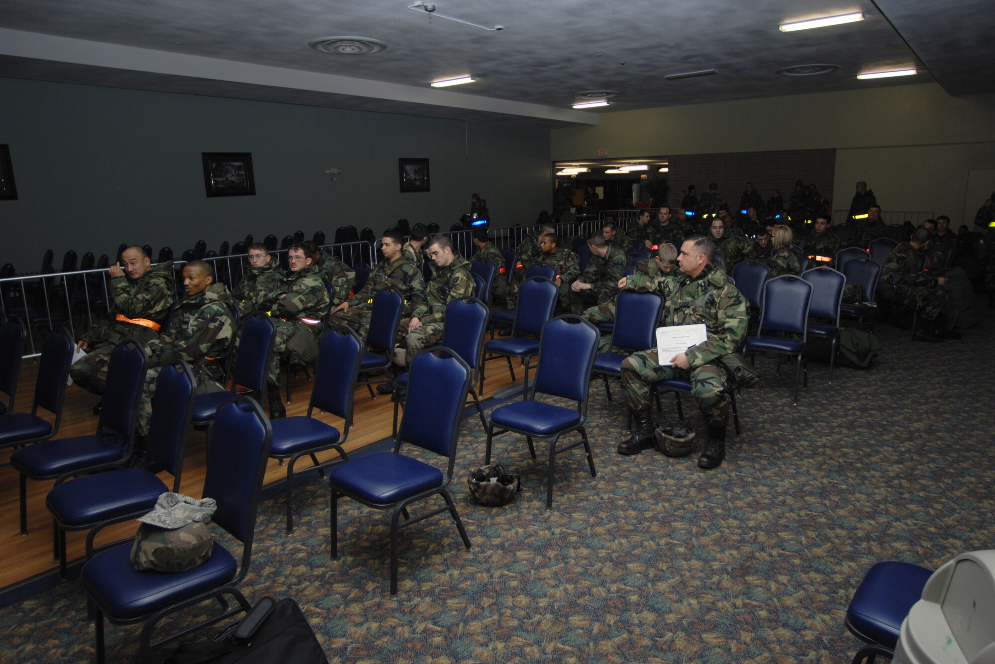 MOUNTAIN HOME AIR FORCE BASE, Idaho -- Deploying Airmen from the 366th Services Squadron await a pre-deployment briefing as they start to process through the personnel deployment function during Exercise Sharpshooter 08-03 here, Feb. 4. The PDF line consists of baggage drop off, numerous briefings about the nature of the deployment and a last check to make sure paperwork is in order. The 366th Fighter Wing conducts exercises to prepare personnel and equipment for the upcoming March 2008 Operational Readiness Inspection. (U.S. Air Force photo by Airman 1st Class Ryan Crane)