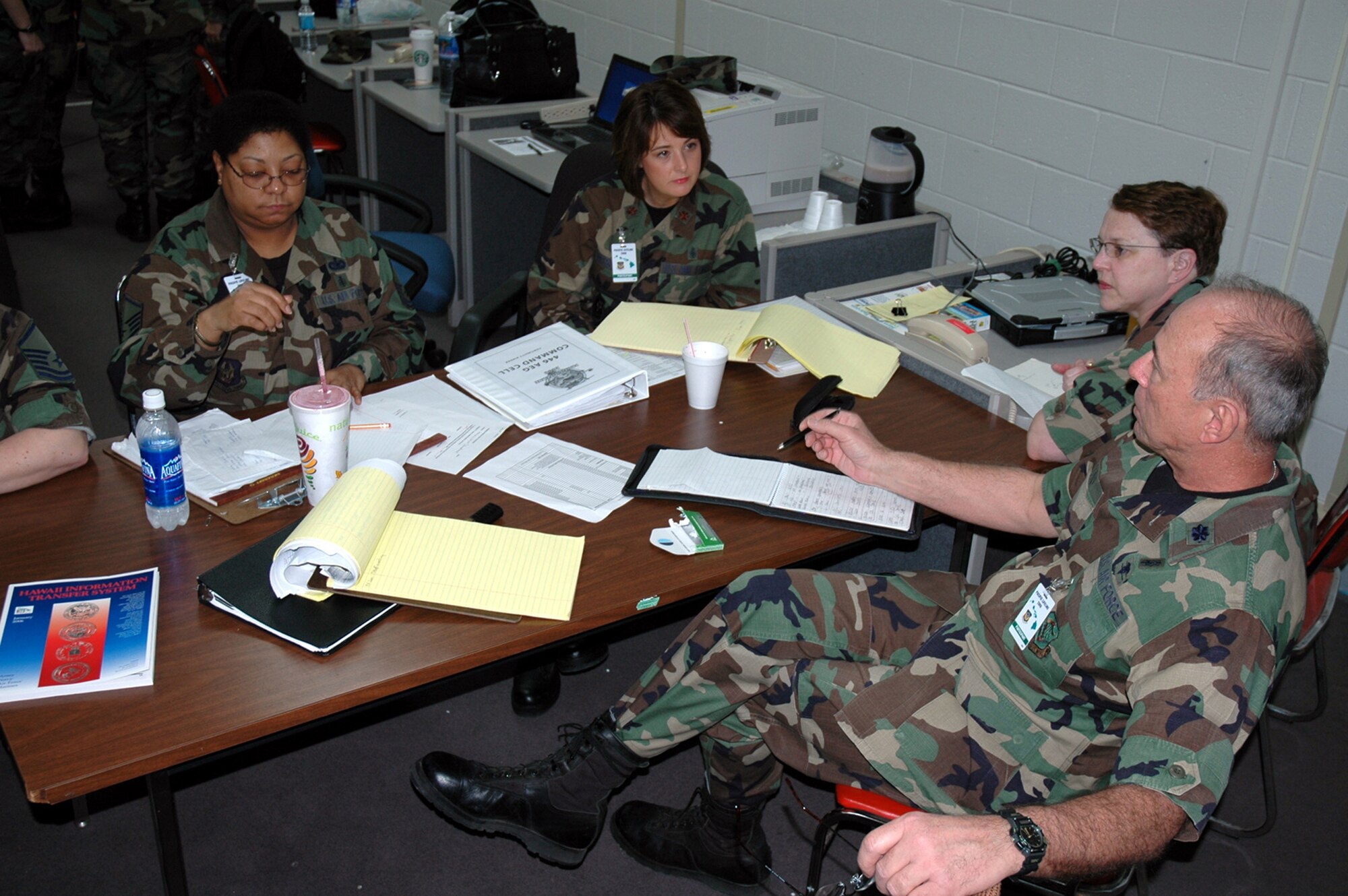 Master Sgt. Rita Herrington, Maj. Michelle Emerson , Lt. Col. Julia Scott, and Lt. Col. Pat Pound, the Aeromedical Command Cell for the Pacific Lifeline exercise, discuss operations Jan. 31. Pacific Lifeline is a humanitarian assistance disaster response exercise taking place over three Hawaiian Islands Jan. 26 to Feb. 9. The command cell provides oversight for all aeromedical operations, the mobile aeromedical staging facility, the aeromedical liaison team, and the aeromedical operations team during the exercise. More than 900 Department of Defense personnel are participating in the exercise. The command cell members are all from the 446th Aeromedical Evacuation Squadron. (U.S. Air Force photo/Capt. Jennifer Gerhardt)