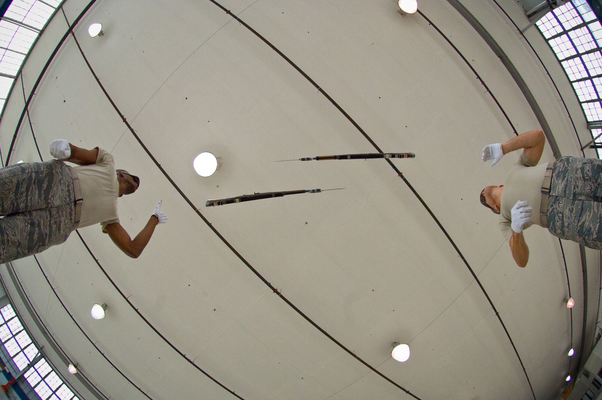 Staff Sgt. Jason Martin, Drill Team head trainer (right), and Senior Airman Jermaine James, Drill Team trainer (left), perform an overhead weapon exchange while training for their 2008 performance sequence. (US Air Force Photo/Donna Burnett)