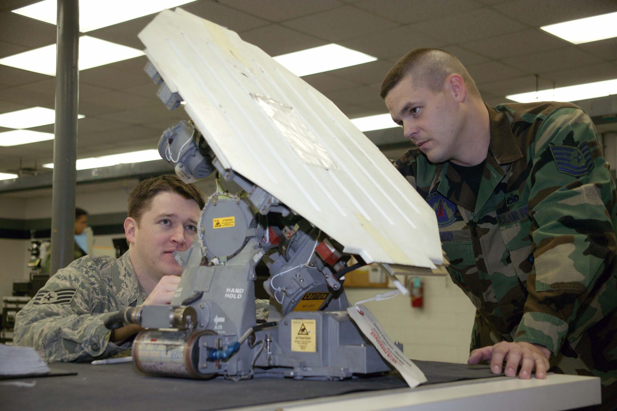 SHAW AIR FORCE BASE, S.C. -- Tech. Sgt. Robert Reed (right), 20th Component Maintenance Squadron avionics section assistance chief, inspects a radar antenna with Staff Sgt. Joseph Brockman, 20th CMS, in the avionics workshop Jan. 22. Sergeant Reed earned the Sumter's Chamber of Commerce Military Citizen of the Year Award for his community involvement and volunteer activities. (U.S. Air Force photo/Staff Sgt. John Gordinier)