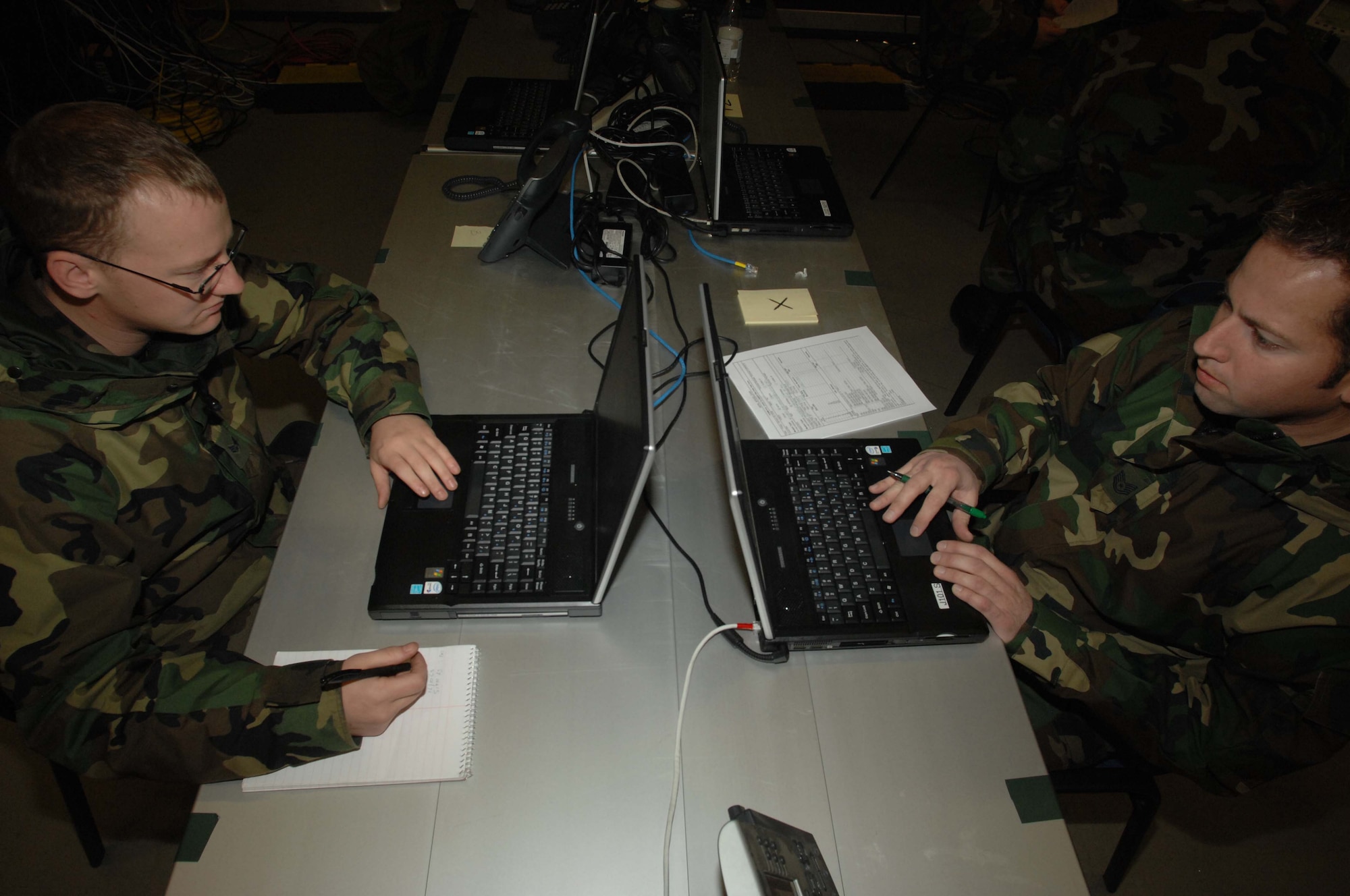 Senior Airman Lee Harvey, 1st Combat Communications voice technician, and Tech. Sgt. Michael Ehemann, Headquarters Air Mobility Command  Mobile C2 Research and Integration Facility, work in unison to certify the transfer of data between communication systems Jan. 25 on Ramstein Air Base. The purpose of the Teleport Certification is to satisfy communications requirements and objectives of worldwide coverage and connectivity, interoperability, and responsiveness. (U.S. Air Force photo/Airman 1st Class Amber Bressler)(RELEASED)