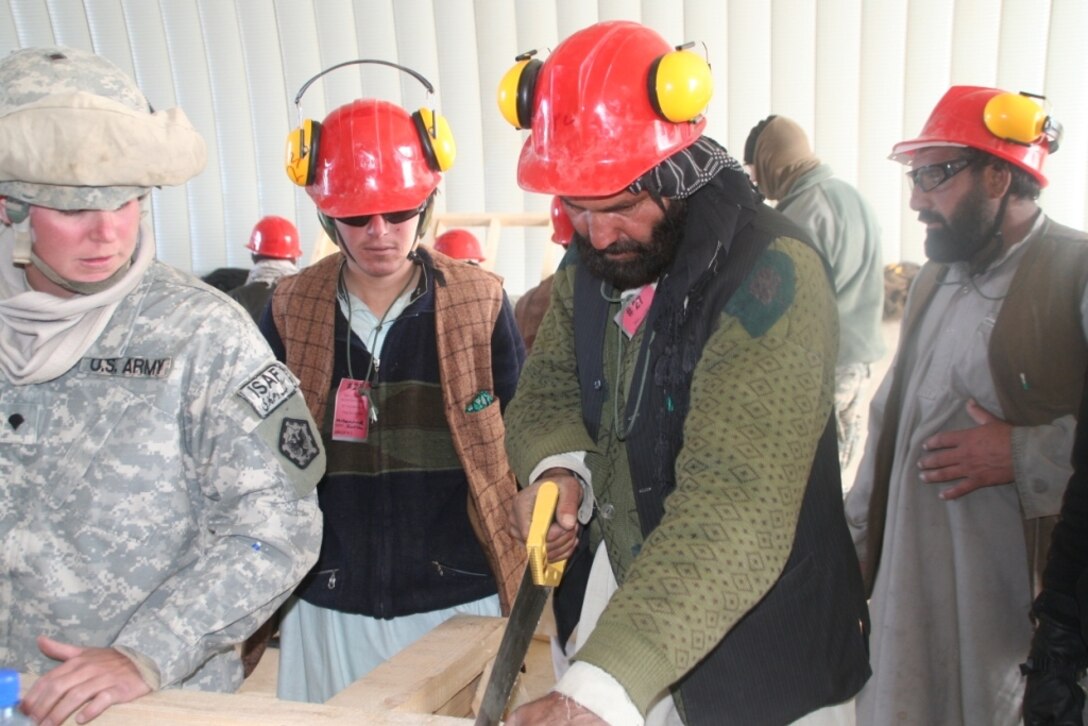 Army Spc. Jennifer Sims teaches a group of Afghans basic carpentry skills at Forward Operating Base Sharana, Afghanistan. Photo by 1st Lt. Kenya Virginia Saenz, USA