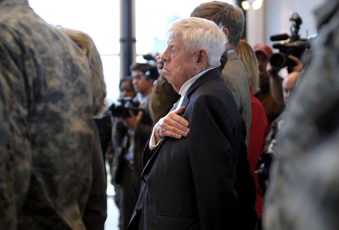 Alexander Milley, a U.S. Marine Corps veteran of World War II, places his hand over his heart during the playing of the national anthem at the start of the promotion ceremony for his son, Army Col. Mark Milley, to brigadier general on Fort Campbell, Ky., Feb. 1, 2008. 