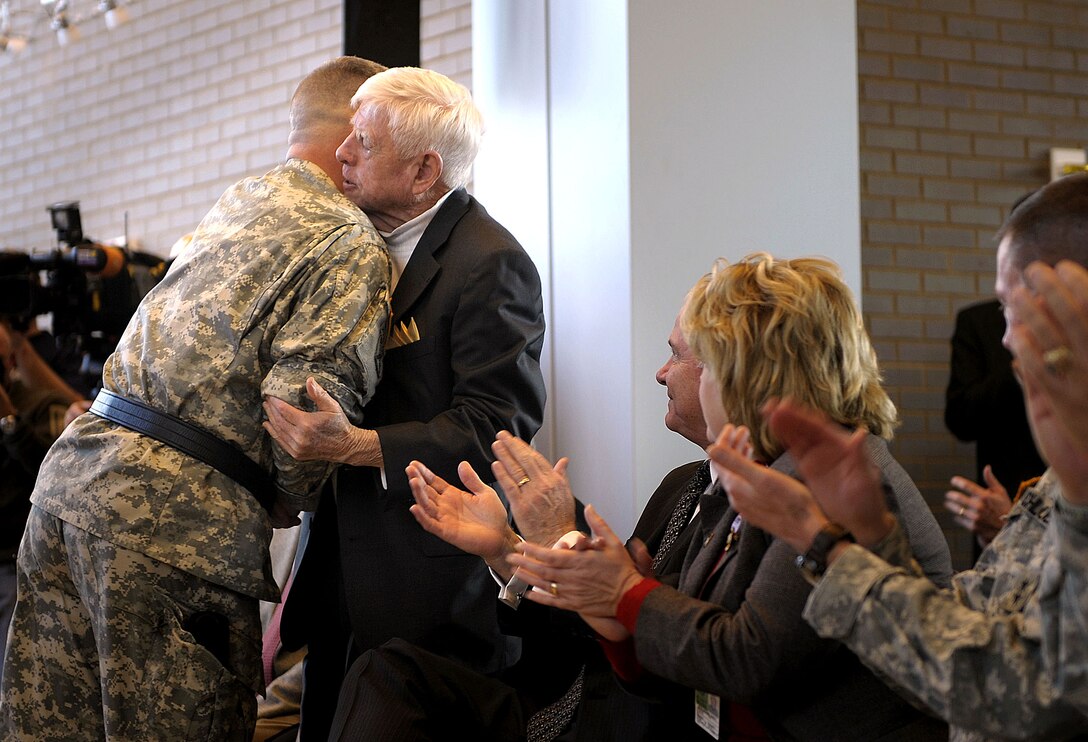 Brig. Gen. Mark Milley, deputy commander of operations for the 101st Airborne Division Air Assault, gives out his first general's coin to his father, Alexander Milley, during his promotion ceremony at Fort Campbell, Ky., Feb. 1, 2008.  