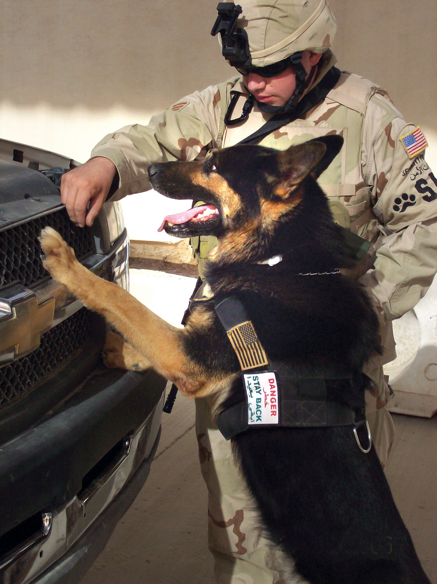 SrA Shawn Kaup and military working dog, Rexo, inspect a vehicle at a check point in Baghdad. Courtesy photo