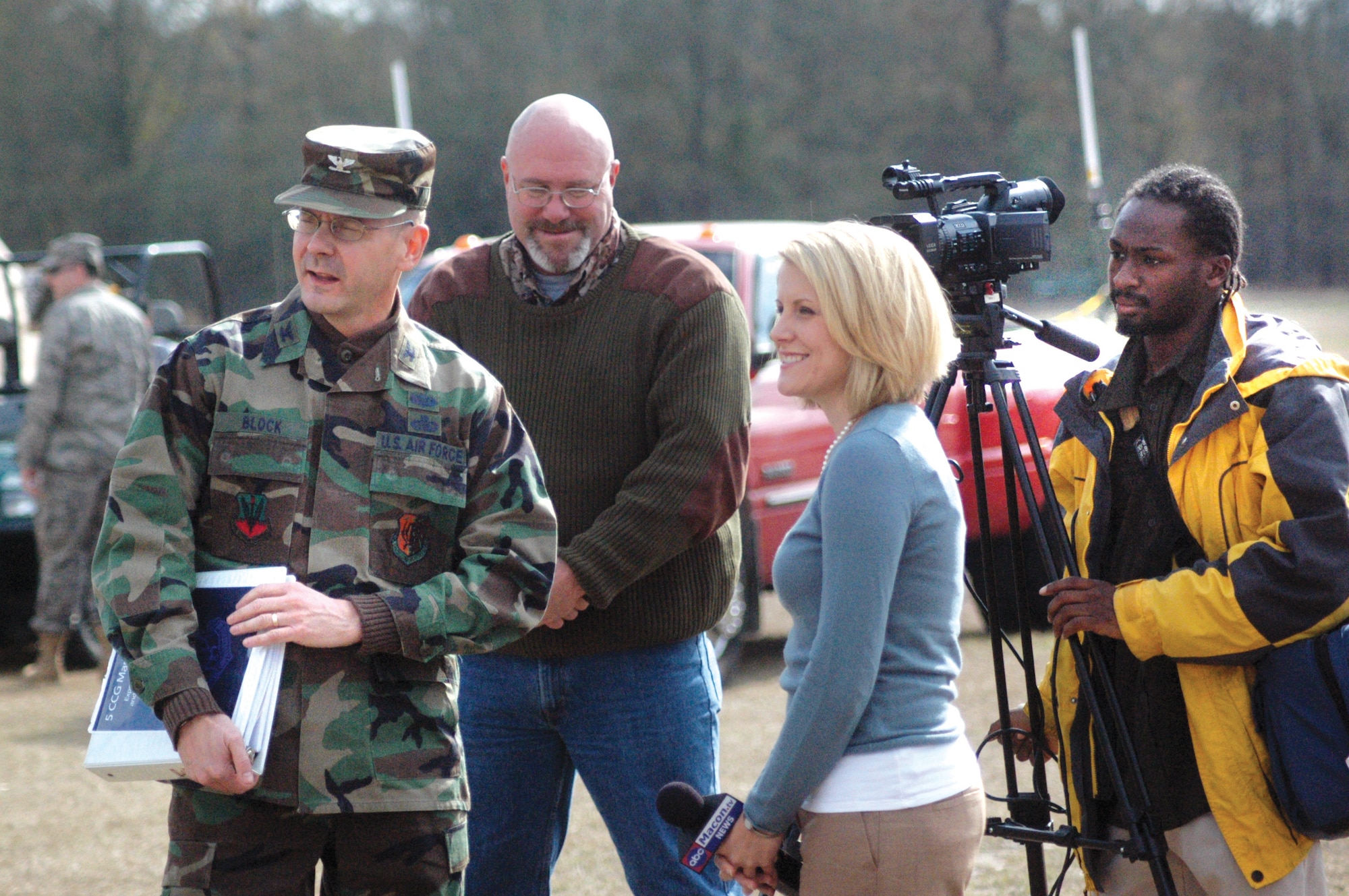 Col. Carl Block, 5th Combat Communications Group commander, explains an exercise senario to  George Jozens, 78th Air Base Wing Public Affairs officer, Claire Simms, WPGA reporter and Alan Lincoln, WPGA videographer. U. S. Air Force photo by Sue Sapp