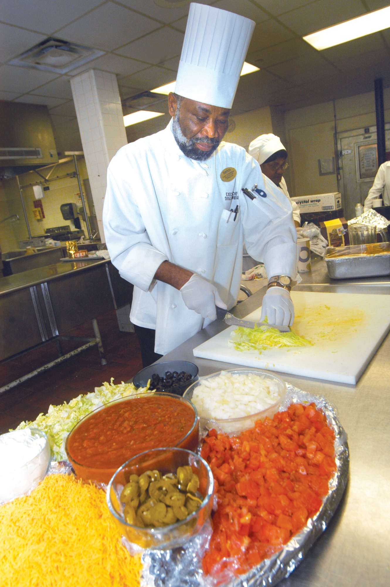 Douglas Goodridge chops lettuce in the officers club kitchen. He is the new executive chef at Robins Officer and Enlisted Club. U. S. Air Force photo by Sue Sapp      