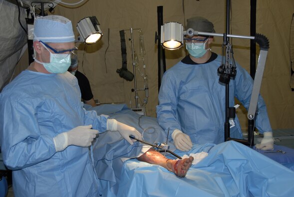 KONA, Hawaii -- Lt. Col. Greg Schumacher, a orthopedic surgeon (left), from the 3rd Medical Group, Elmendorf AIr Force Base, performs a fracture stabilization procedure by inserting a steel pin in the leg of a mannequin. Senior Airmen Wallace Cleveland, a 3 rd EMED surgical technician (right) assists. The mock surgery was part of an exercise evaluation performed on a patient during a mass casualty exercise at the Kona International Airport, Kona, Hawaii, Feb. 4. The Airman are two of more than 900 Department of Defense personnel participating in Pacific Lifeline, a total force humanitarian assistance and disaster relief exercise taking place from three locations within the Hawaiian Islands through Feb. 9. Led by 13th Air Force, Pacific Lifeline provides an integrated team of Air Force and Army active-duty, Air National Guard and Reserve Component forces a training environment to test their abilities to respond to and support humanitarian and natural disaster relief operations within the Pacific Region. (U.S. Air Force photo/Tech. Sgt. Tom Czerwinski) 
