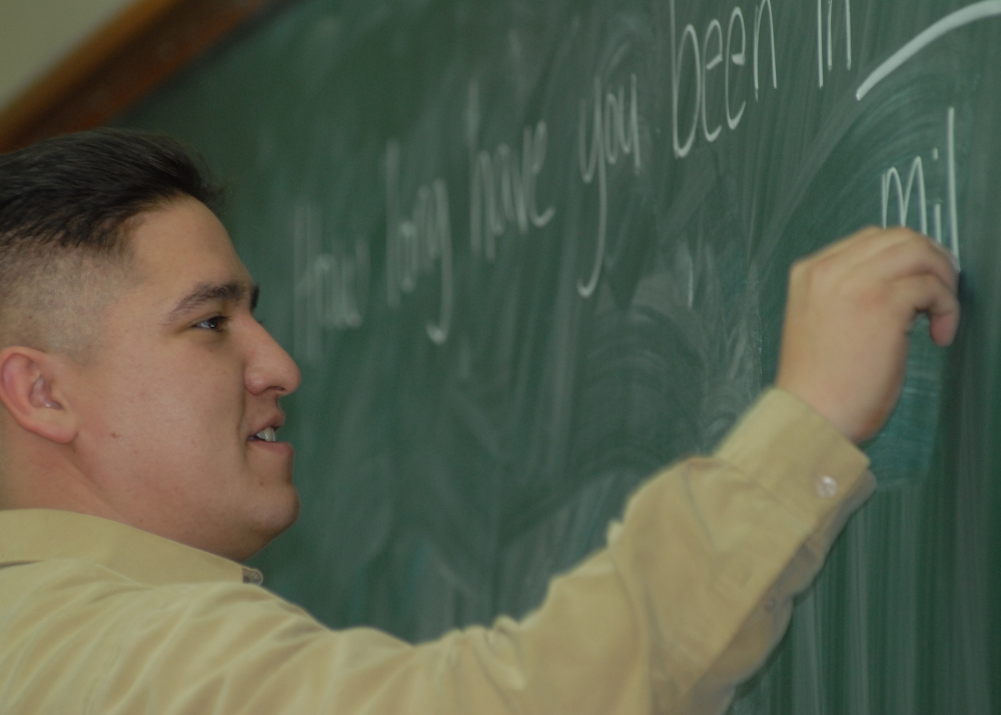 KUNSAN AIR BASE, South Korea -- Staff Sgt. Jon Powell writes down common English greetings on the black board here 31 Jan. Numerous Airmen from the 5/6 group take the opportunity throughout the year to assist ROK Cadets in learning English as part of the academy’s curriculum. Sergeant Powell is the non-commissioned officer in charge of visual imagery and intrusion detection systems and wideband maintenance with the 8th Communications Squadron.  (U.S. Air Force Photo/Staff Sgt Araceli Alarcon)