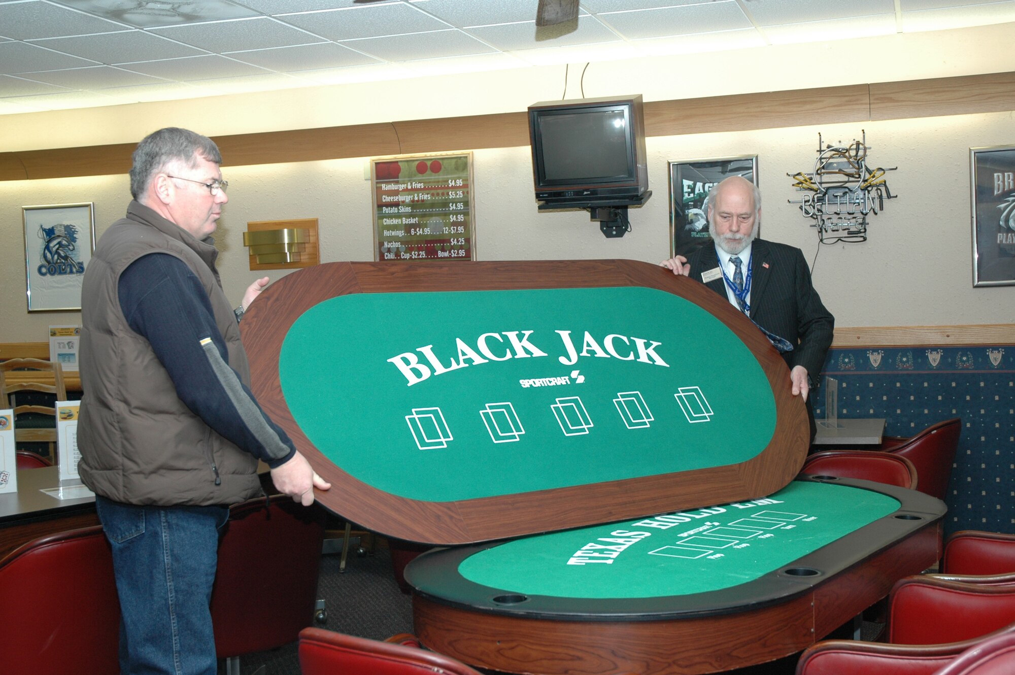 Joseph Vieth, 341st Services Squadron community support flight chief, and Robery Espelund, manager of the Grizzly Bend Club, prepare to move a black jack table from the old location of the sports bar to the new location, upstairs in the club, Feb. 2. Rennovations to the club are scheduled to be completed Feb. 8. (U.S. Air Force photo/Airman 1st Class Emerald Ralston)