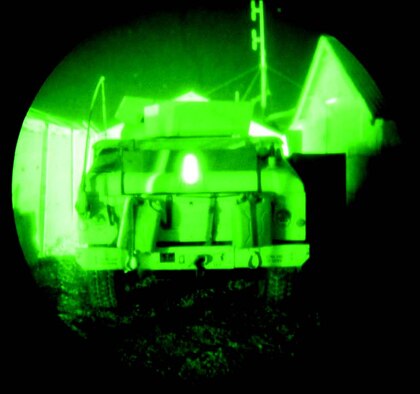 Military vehicle marked with TRON I (glowing strip in the center) and TRON III, as viewed through night vision goggles