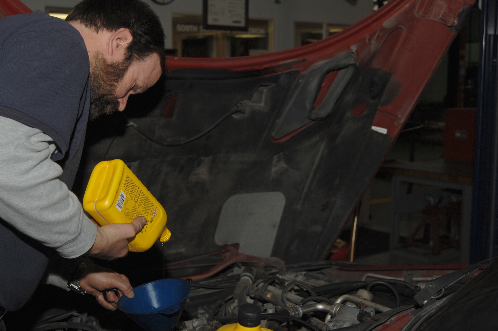 Frank Judkins, Mobile Equipment Technician 509th Services Squadron, performs an oil change on a customer’s vehicle. The services squadron was notified Jan. 29 that they are the recipients of the 2007 Maj. Gen. Eugene L. Eubank Award for the Best Small Services Squadron in Air Combat Command. "This is a significant accomplishment  for all the members of the 509th SVS, said Major Kevin Naman, 509th SVS commander. "This award signifies that we are providing the absolute best support possible in a very challenging environment." (U.S. Air Force photo/Airman 1st Class Jessica Snow)