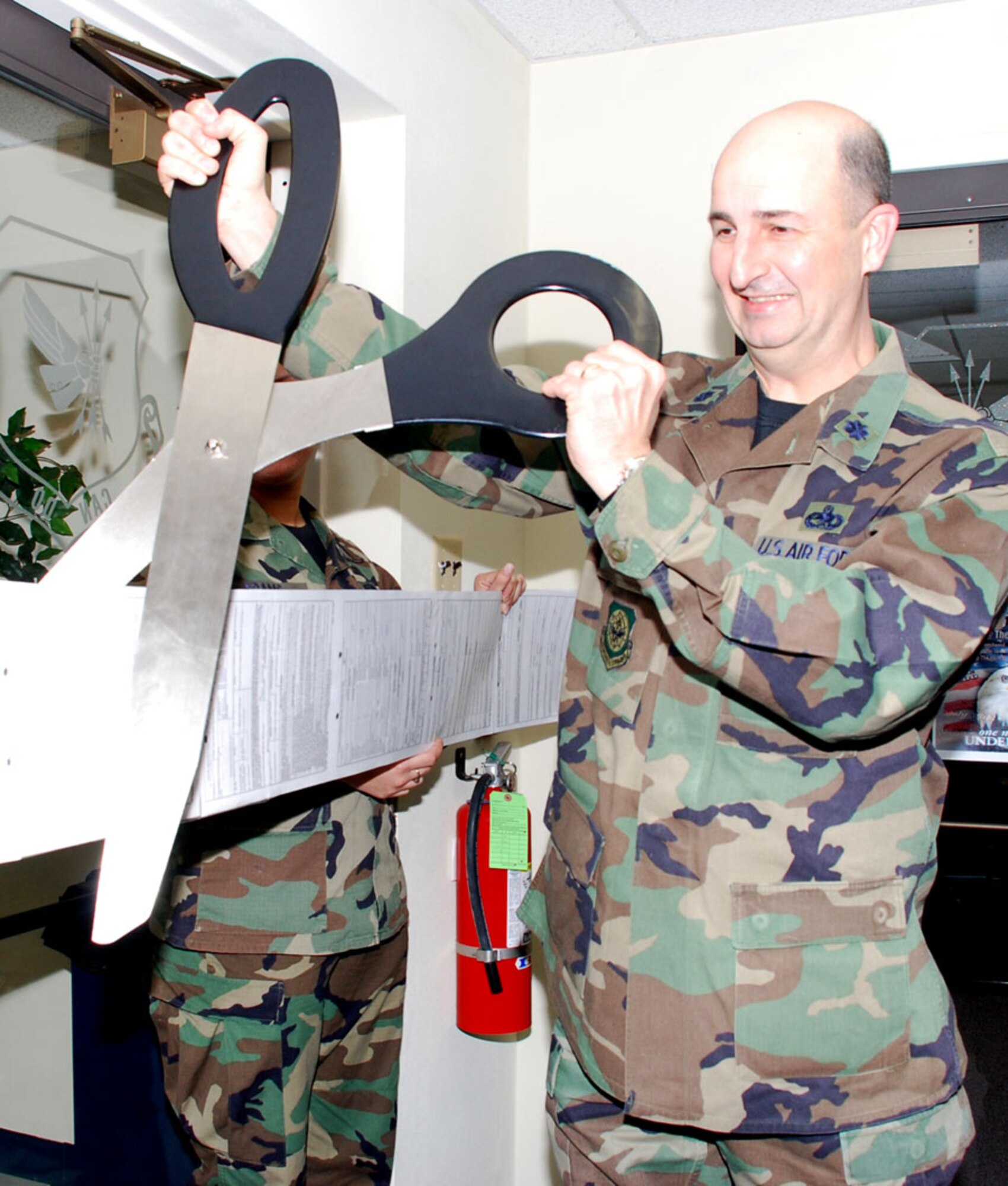 Lt. Col. James Wagner, 305th Mission Support Group deputy commander, cuts the "ribbon" for the Military Personnel Element grand opening here Feb. 4. The MPE was formed by combining the commanders' supprt staff personnel from each of the groups along with the Military Personnel Flight. This MPE consolidates all functions of the CSSs and MPF into one location and is expected to enhance customer service. (U.S. Air Force photo/Senior Airman Danielle Johnson)