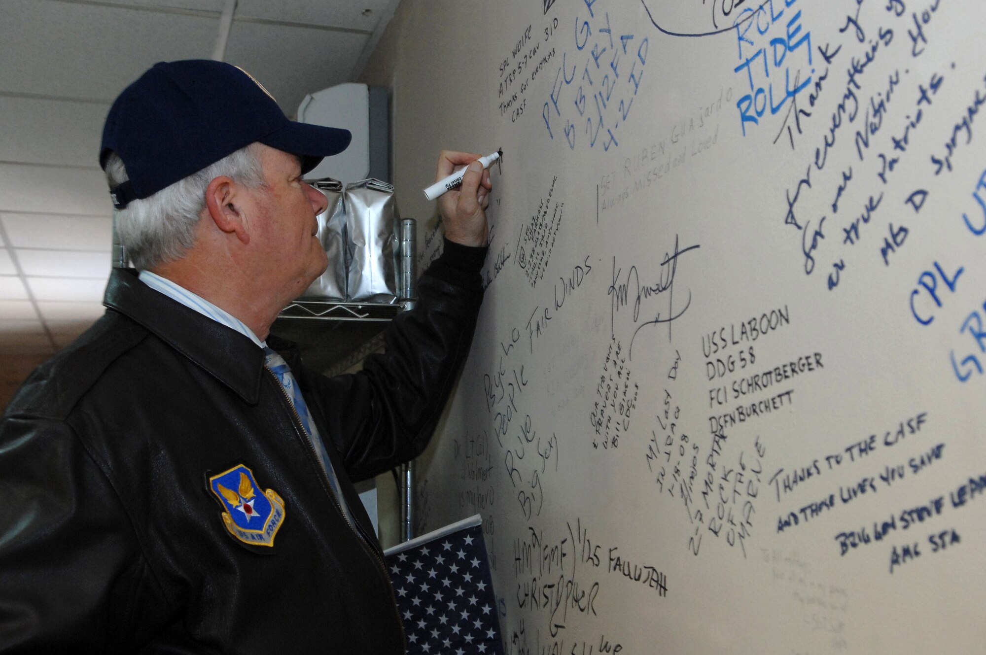 Secretary of the Air Force Michael Wynne signs his name on a wall at the Contingency Aeromedical Staging Facility here, Feb. 2. The CASF is a component of the Air Force Theater Hospital where injured servicemembers are transported from the area of responsibility to hospitals in Germany and the U.S. (U.S. Air Force photo/Senior Airman Julianne Showalter)