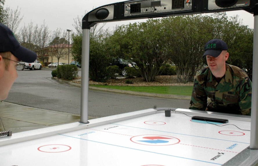 Airman 1st Class Chris Reicherts, 60th Equipment Maintenance Squadron, moves the air hockey table he won from the Airman's Attic. Every month the Airman's Attic will hold a drawing. This month, the Attic will give away a DVD player and a bike. The Airman's Attic is located in Bldg. 241. (U.S. Air Force photo/Senior Airman Shaun Emery)