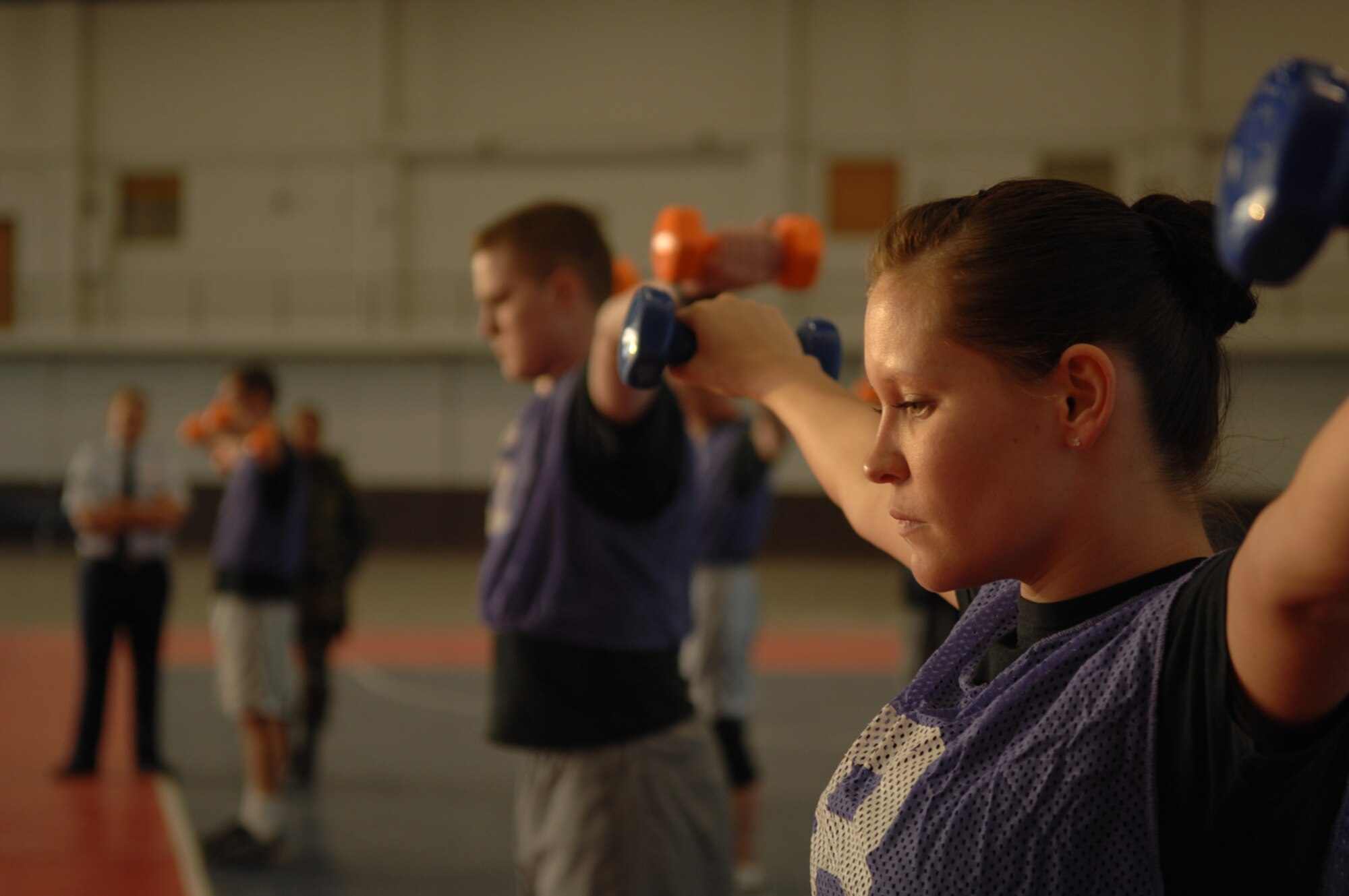 Senior Airman Arianna Moore, Air Force Financial Services Center, 28th Bomb Wing, holds up 2.5 pound weights for as long as possible during the final challenge in the Iron Flight competition, Jan 31.  Four squadrons participated in the event; Communications, Logistics Readiness, Services, and the Air Force Financial Services Center.  (U.S. Air Force photo/Senior Airman Anthony Sanchelli)