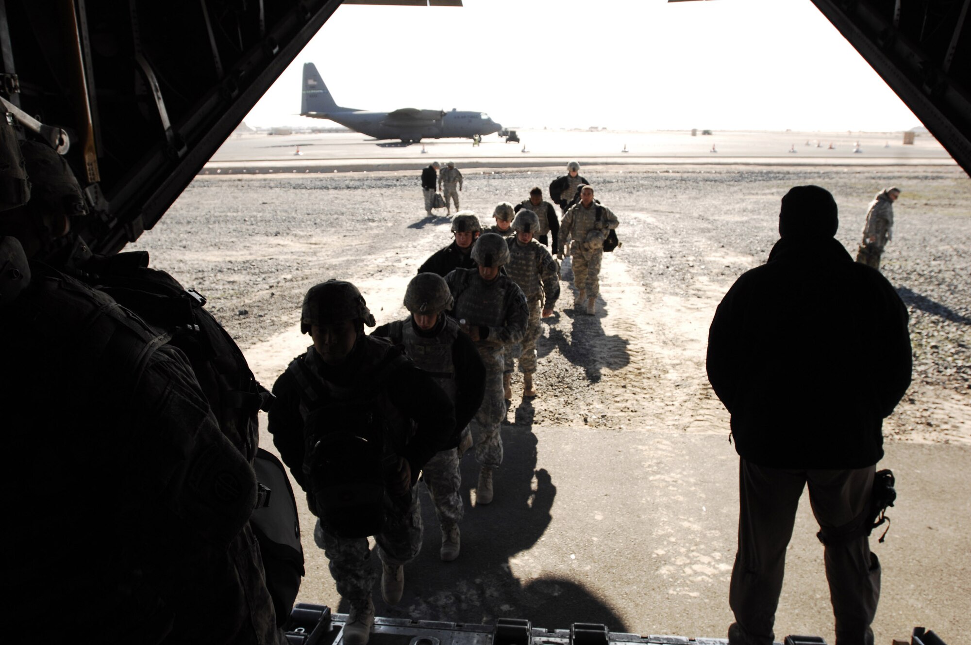 SOUTHWEST ASIA -- U.S. Soldiers enter a C-130H Hercules on Feb. 4, 2008, at an air base in the Persian Gulf Region. The Soldiers are heading to locations throughout the area of responsibility for Operation Iraqi Freedom. (U.S. Air Force photo/ Staff Sergeant Patrick Dixon)