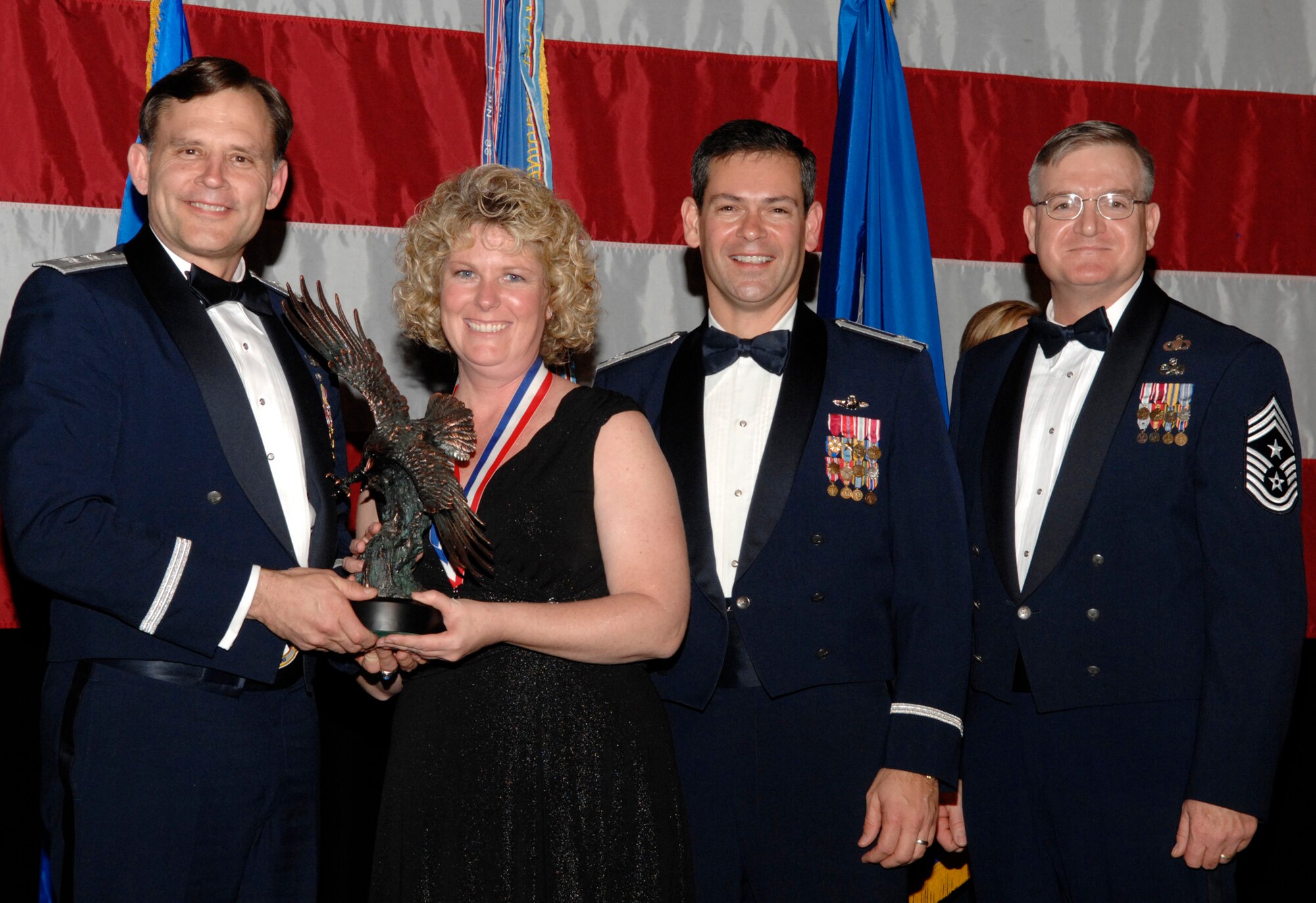 Victoria Fogarty, 82nd Aerial Targets Squadron, won the 53d Wing Category 2 Civilian of the Year Award during the annual awards banquet Jan. 31 at the Emerald Coast Conference Center.  The night’s guest speaker and former 53d commander, Maj. Gen. (retired) Jack Catton (left) presented the awards. Col. Ken Wilsbach, 53d Wing commander, and Chief Master Sgt. Randy Salefske, 53d Wing command chief, also stand with the winner.  U.S. Air Force photo.