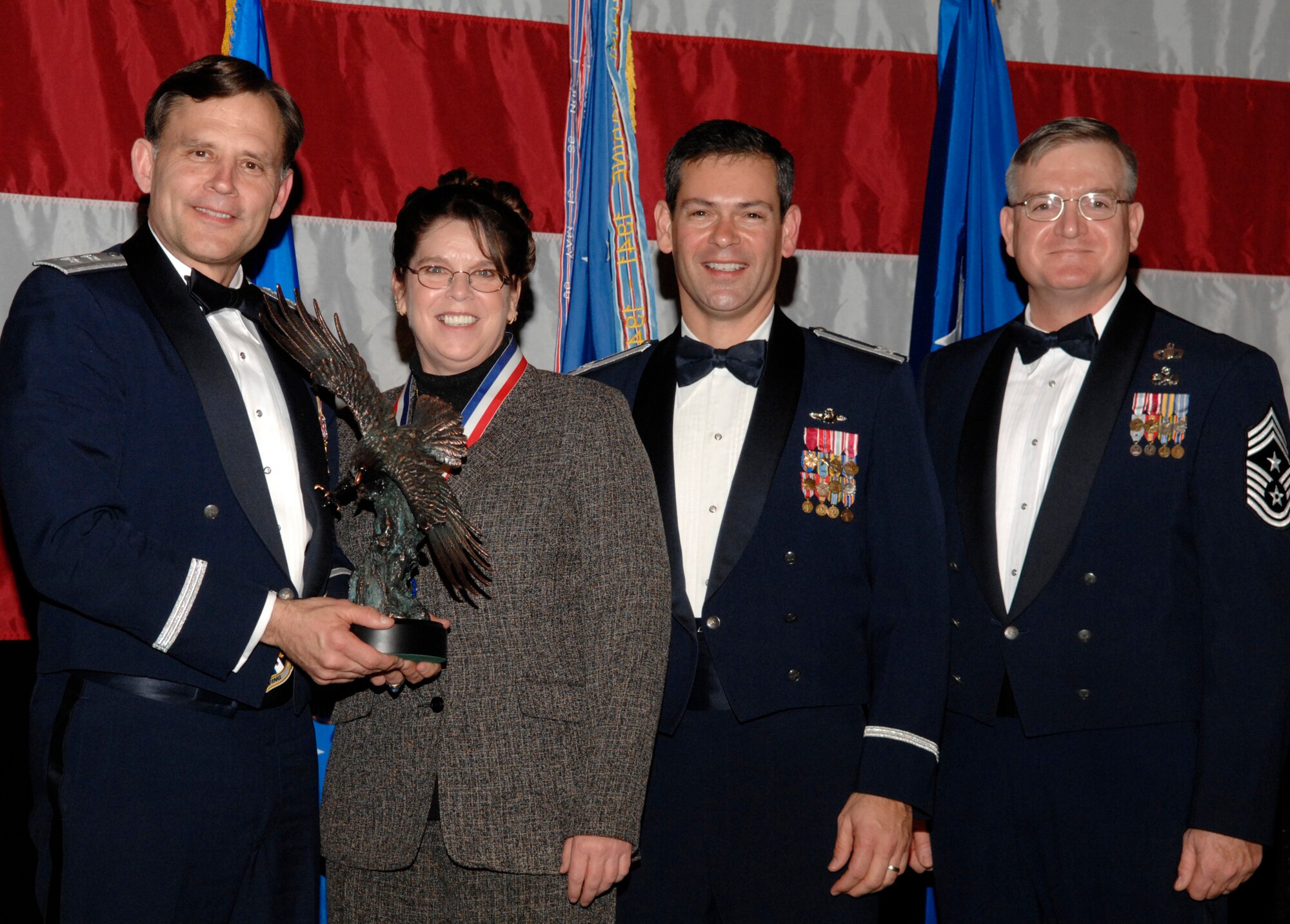 Phyllis Herald, 53d Test and Evaluation Group, won the 53d Wing Category 3 Civilian of the Year Award during the annual awards banquet Jan. 31 at the Emerald Coast Conference Center.  The night’s guest speaker and former 53d commander, Maj. Gen. (retired) Jack Catton (left) presented the awards. Col. Ken Wilsbach, 53d Wing commander, and Chief Master Sgt. Randy Salefske, 53d Wing command chief, also stand with the winner.  U.S. Air Force photo.