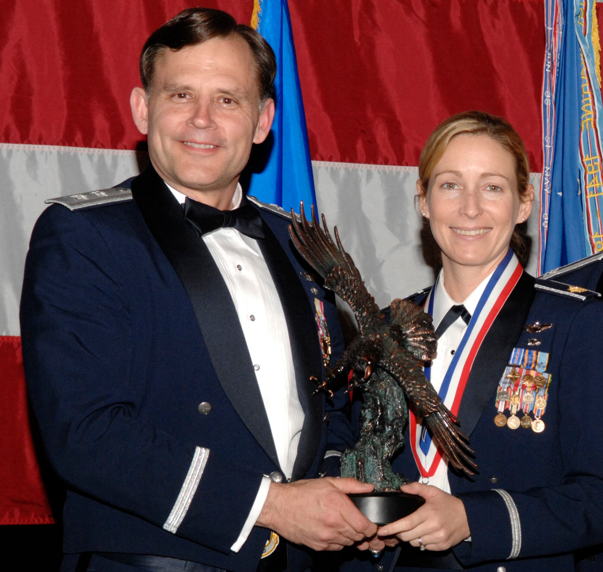 Maj. Kim Campbell, 422nd Test and Evaluation Squadron, won the 53d Wing Field Grade Officer of the Year Award during the annual awards banquet Jan. 31 at the Emerald Coast Conference Center.  The night’s guest speaker and former 53d commander, Maj. Gen. (retired) Jack Catton (left) presented the awards.  U.S. Air Force photo.