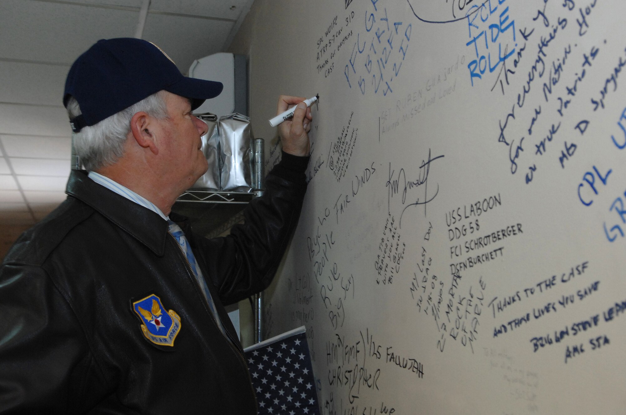 BALAD AIR BASE, Iraq -- Secretary of the Air Force Michael Wynne signs his name on a wall at the Contingency Aeromedical Staging Facility here, Feb. 2. The CASF is a component of the Air Force Theater Hospital where injured servicemembers are transported from the Area of Responsibility to hospitals in Germany and the U.S. (U.S. Air Force photo/ Senior Airman Julianne Showalter)