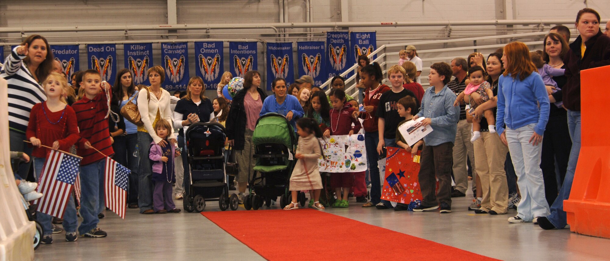 Family and friends look on anxiously as their loved ones step off the plane during Operation Homecoming at Commando Hangar Feb. 5. Approximately 250 Airmen returned from deployments to the Middle East.  (U.S. Air Force photo/Airman 1st Class Sheila DeVera)
