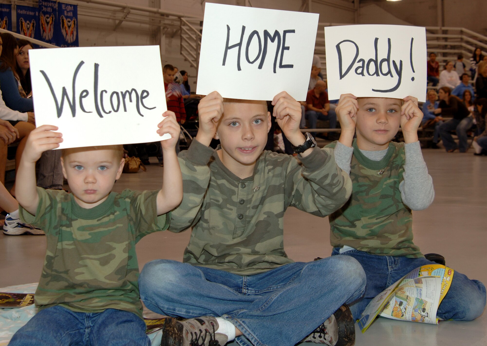 Capt. Aaron Riess' three sons wait patiently to see their dad for the first time in months during Operation Homecoming in Commando Hangar Feb. 5. Dad's return was a special present for Nathan (middle) who celebrates his 10th birthday today. Captain Riess was one of 250 Airmen who returned from deployments to the Middle East. (U.S. Air Force photo/Airman 1st Class Sheila DeVera)