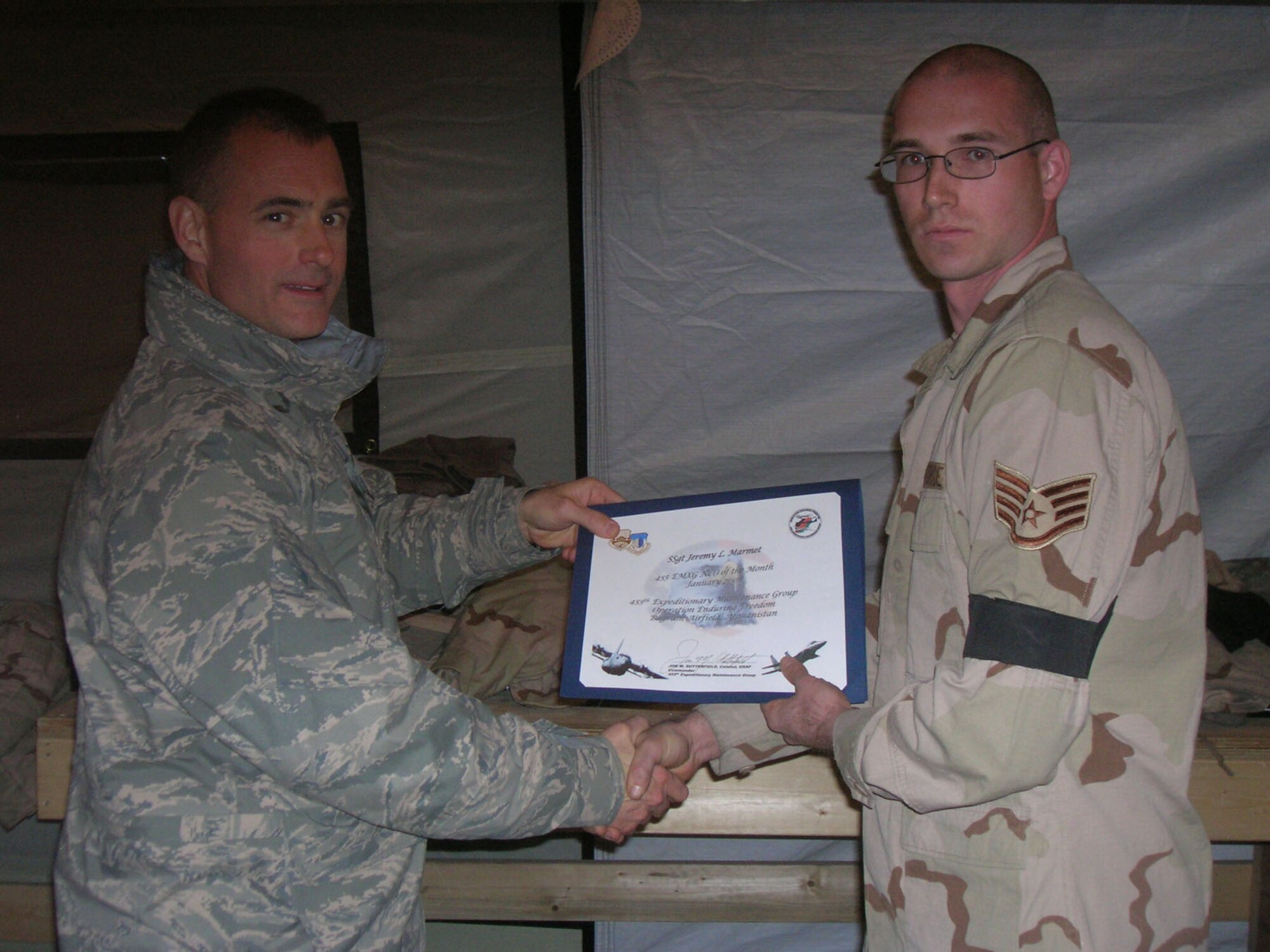 BAGRAM AIR BASE, Afghanistan -- Col. Jon Sutterfield, 455th Expeditionary Maintenance Group commander, presents Staff Sgt. Jeremy Marmet, 455th Expeditionary Aircraft Maintenance Unit, a certificate for being named the 455th Air Expeditionary Wing noncommissioned officer for the month of January. Sergeant Marmet is deployed from Spangdahlem Air Base, Germany. (U.S. Air Force photo/1st Lt. Nicholas Bosiak)